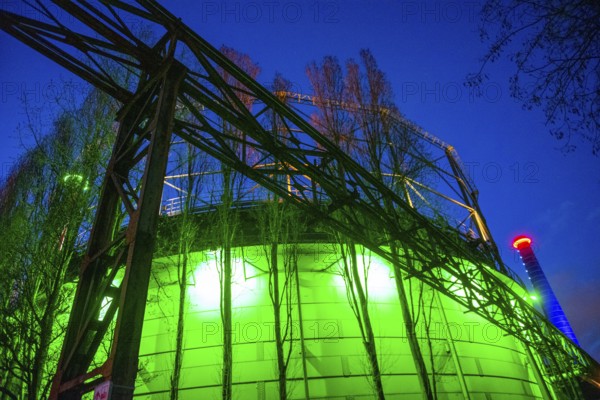 Industrial building illuminated at night in green with steel structures, Landschaftspark Duisburg