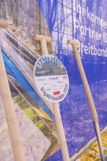 Spade in front of a poster referring to network expansion and construction, fiber optic