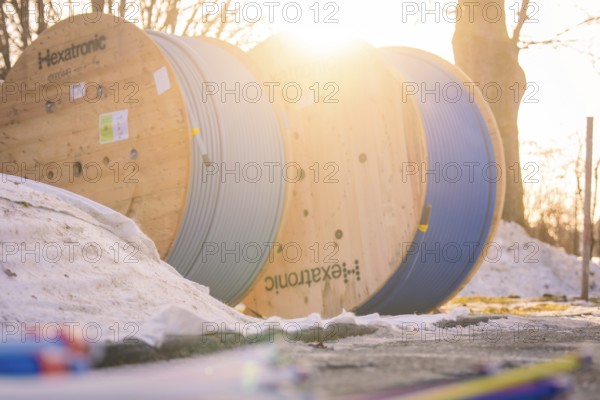 Cable drums in the snow, steeped in warm morning light, create a wintry atmosphere, fibreglass