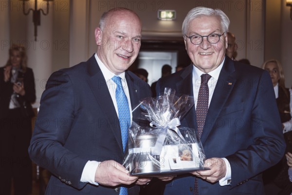 Kai Wegner and Frank-Walter Steinmeier with a gift in front of a dinner in honor of the Honorary