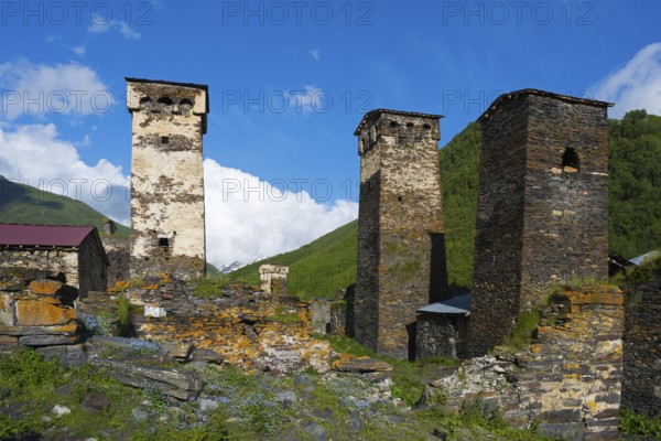 Stone towers in a historic village under clear blue sky in a hilly landscape, defensive towers,