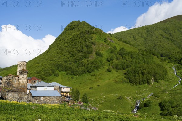 A green mountain with stone houses under a cloudy sky, defensive towers, Ushguli, Ushguli, Murqmeli