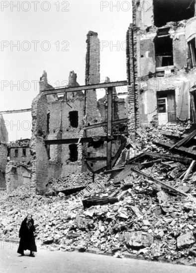 Civilians, an old woman in front of the rubble of a residential building, Berlin April 1945,