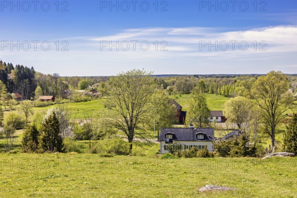 Beautiful landscape view with meadows and fields and residential houses in the countryside on a