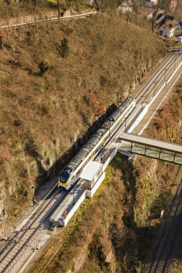 Aerial view of a train near a bridge in a hilly landscape, test run on the new Hermann-Hesse