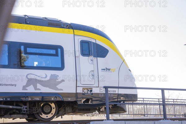 Modern yellow and white train on tracks in sunny surroundings, test run on the new Hermann-Hesse