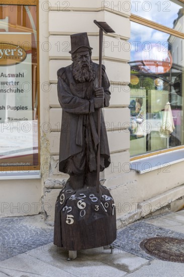 Wooden sculpture of Adam Ries as an arithmetic with numbers, signpost to the Adam Ries House and