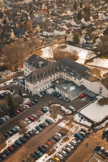 An overview of a building with addresses, parking lot and light snowfall, District Office,