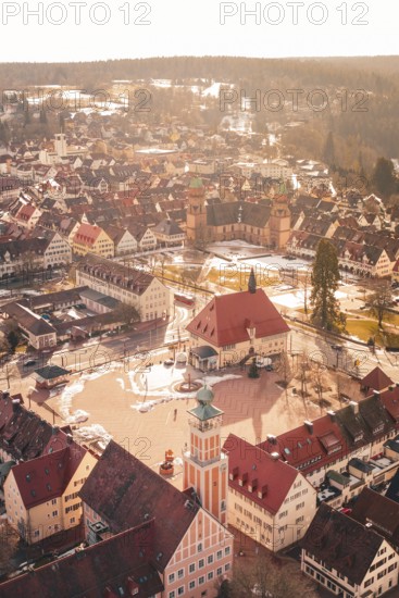City view with church tower and historic buildings covered by light snow at sunset, Freudenstadt,