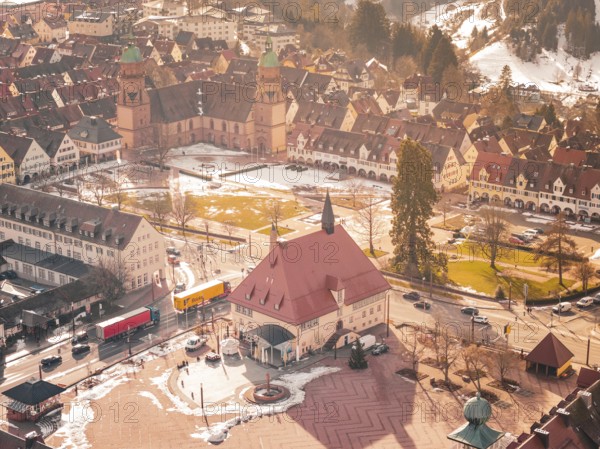 Central square with church and historic buildings in winter, light snow cover available,