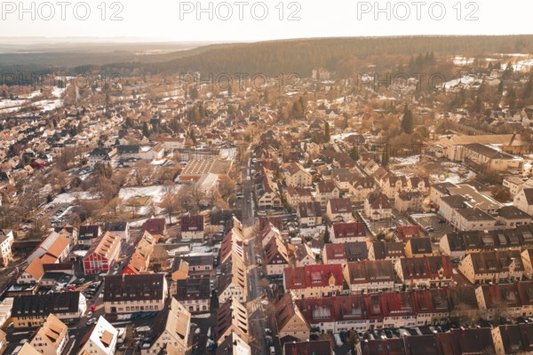 Panoramic view of a city in sunlight with numerous roofs and adjacent forest, Freudenstadt, Black