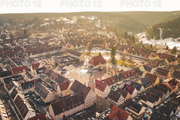 Comprehensive aerial view of an old town with central market square and church in a natural