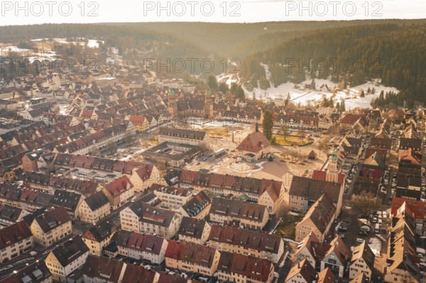 Winter cityscape with central square and red roofs surrounded by wooded hills, Freudenstadt, Black