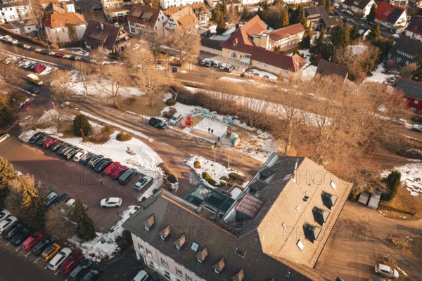 Bird's eye view of a snowy road with buildings and parked cars on a wintry day, Freudenstadt, Black