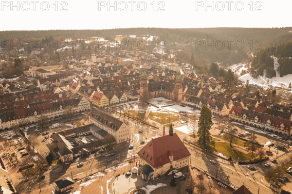 Panoramic view of an old town with distinctive church and snow-covered roofs in winter light,