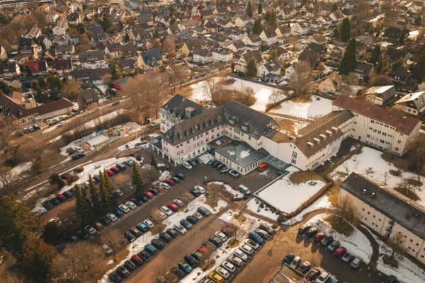 Comprehensive aerial view of a snowy city with cars and buildings in warm colors, district office,