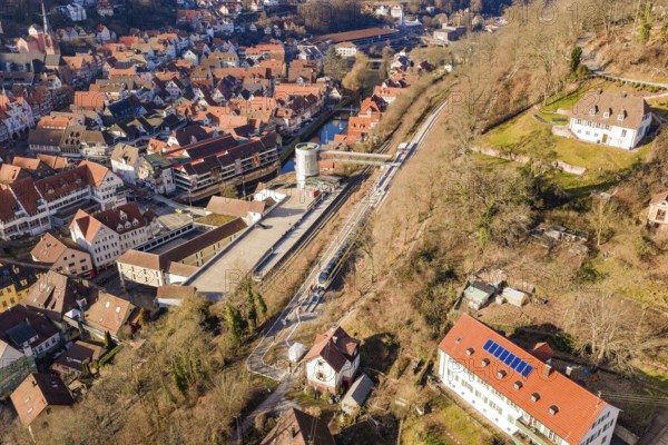 Urban landscape with railway line and river, surrounded by houses from aerial view, test run on the