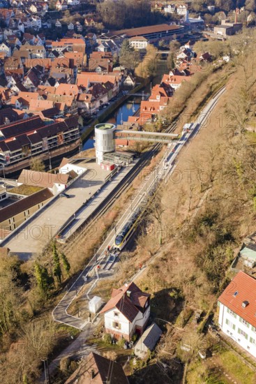 Aerial view of a city with railroad tracks and river surrounded by houses, test run on the new