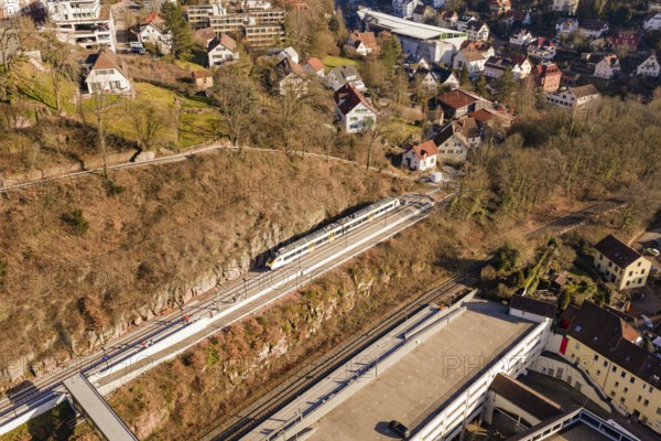 Houses and urban structure on hilly landscape with train on tracks, test run on the new