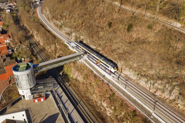 Train ride across bridge in hilly landscape surrounded by vegetation and town houses, test trip on