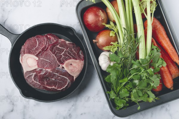 Sknuckle on the bone, raw meat for ossobuco, in a cast-iron pan, baking sheet with vegetables, top