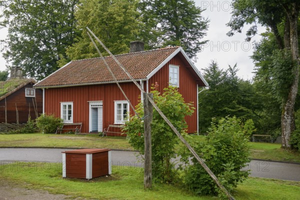 Red wooden house with green garden and trees, Linnés Råshult, Älmhult, Kronobergs län, Småland,