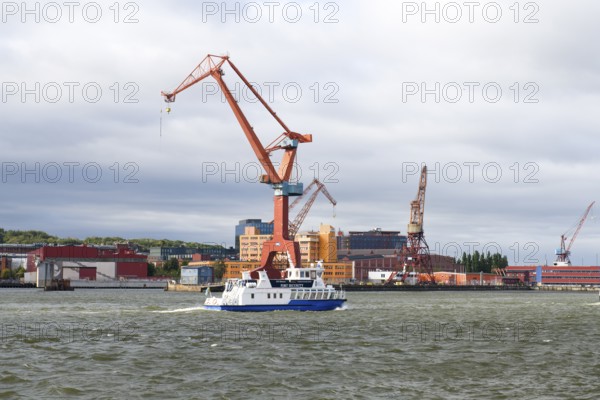 Large industrial port crane and ship on water under cloudy sky in Gothenburg harbour, Gothenburg,