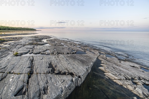 Far-reaching view of the quiet lake Vänern with gently sloping granite rocks archipelago under calm
