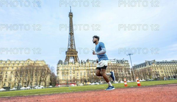 Male athlete intensely running on a red synthetic track, training and exercising with the iconic
