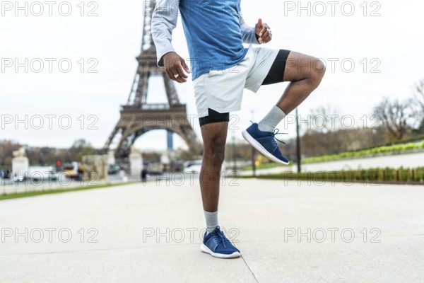African american male athlete engaging in a high knee exercise or warm up routine, demonstrating