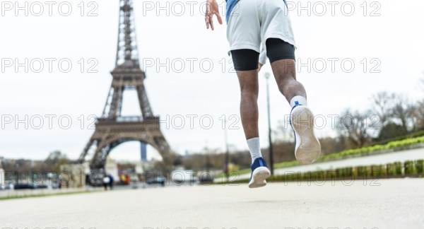 Man running on city street, elevating through a jump or stride, showcasing athleticism and an