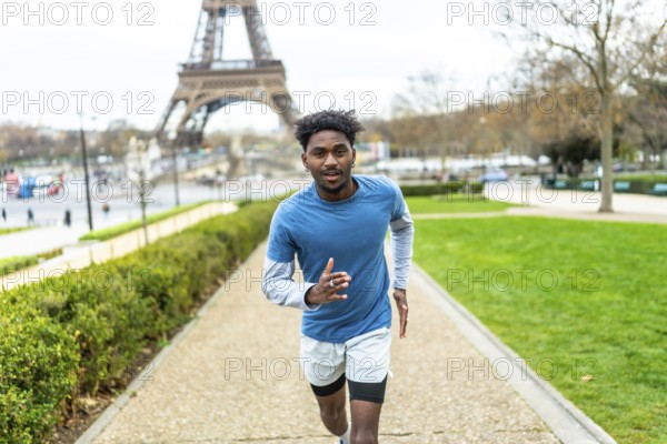 Young black man jogging along a path in a park, maintaining an active lifestyle and fitness routine