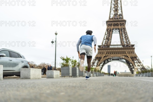 Athletic man sprinting through paris streets for urban training and fitness, eiffel tower rising