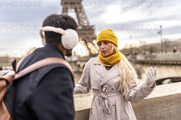 Young couple having an animated conversation outdoors, enjoying a european city break during winter