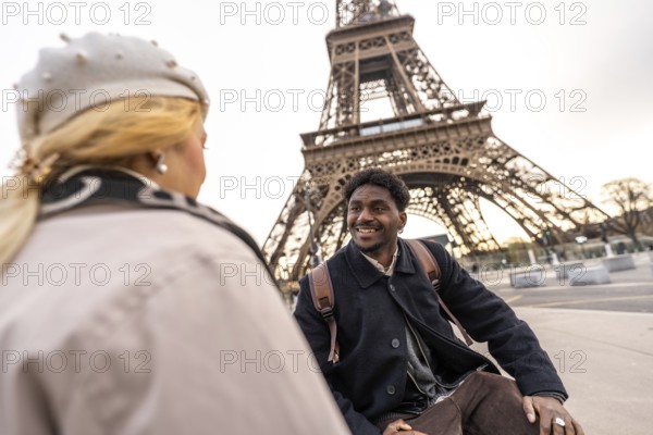 Diverse couple sharing a loving moment while travelling in paris, admiring the iconic eiffel tower