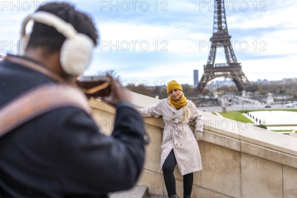 Couple traveling in paris. France. With a man taking a smartphone picture of his blonde girlfriend