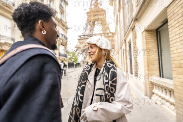 Happy diverse couple smiling and interacting on a parisian street with the eiffel tower in the