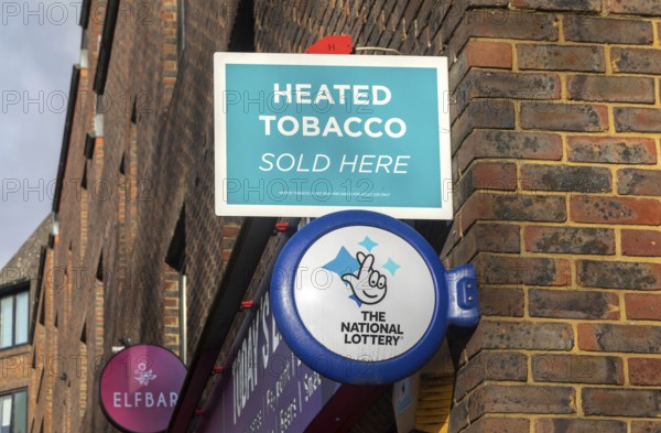 Wall mounted sign for Heated Tobacco Sold Here and The National Lottery, Reading, Berkshire,