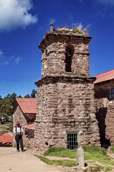 Old church tower with stone tower and a man in traditional clothing, The knitting men on the island