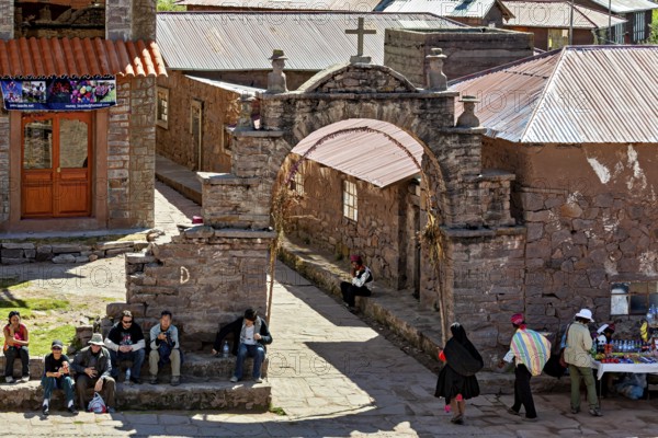 A bustling marketplace in a traditional village with stone walls and arches, The city's large