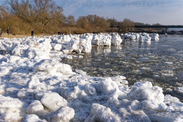 Many visitors look at the icebergs on the water of the Elbe and on the banks of the Elbe Island
