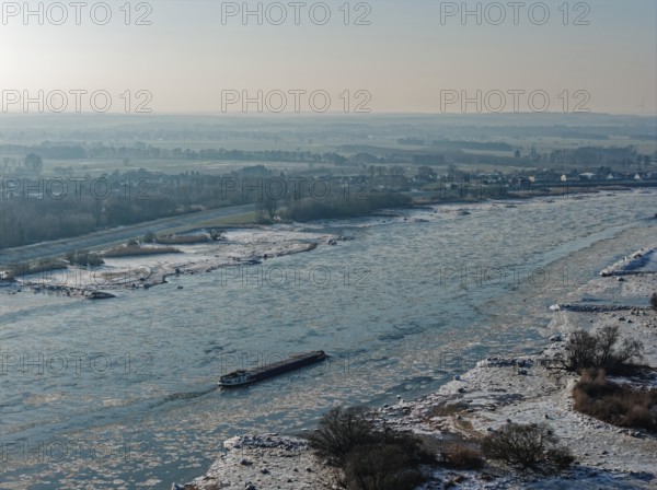On a cold winter day, a barge sails downstream on the Elbe near Hamburg when there is slight ice.
