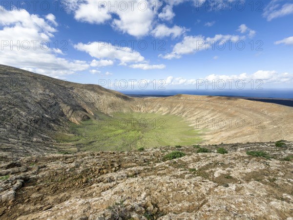 View of the Caldera Blanca volcano cauldron against blue sky with white clouds, Mancha Blanca,