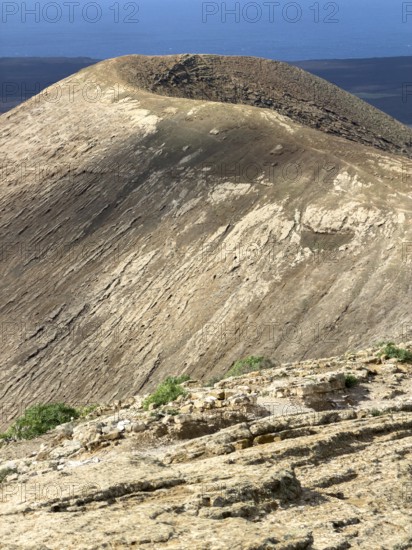 View from Caldera Blanca volcano against blue sky with white clouds, Mancha Blanca, Lanzarote,