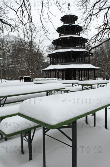 Winter in the English Garden, snow-covered beer garden tables and benches, Chinese Tower, Munich,