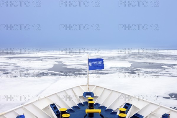 Drift ice, brash ice consists of ice floes and bow of Poseidon Expeditions cruise ship during