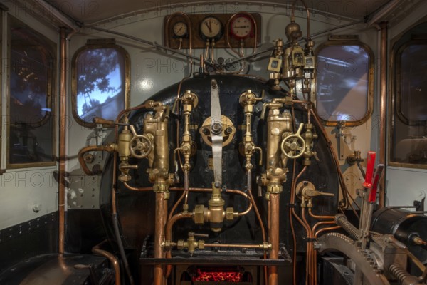 Pressure gauges and valves in steam engine cab, driver's compartment of steam locomotive at Train