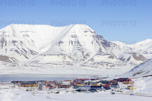 View over the town Longyearbyen on the shore of Adventfjorden and snow covered mountains in winter