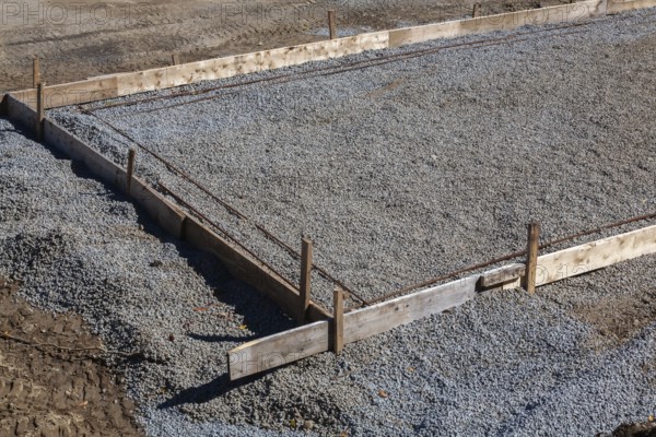 Wooden concrete pouring forms and bed of crushed and compacted stone aggregate to rest concrete