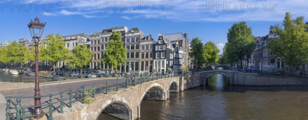 Holland, Amsterdam canals with boats, scenic bridges and historic city center, UNESCO World
